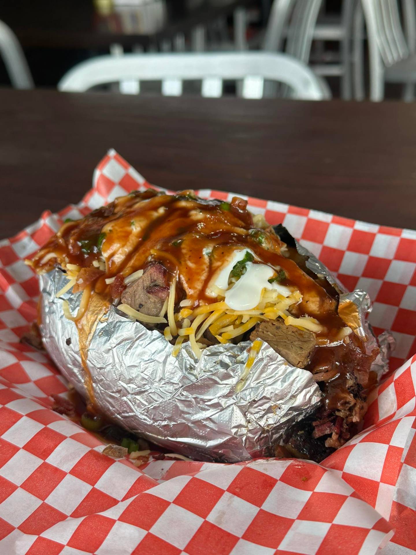 Loaded brisket baked potato with cheese, bacon and BBQ sauce